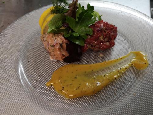 a plate with a piece of food with sauce on it at Hotel DreiKönig & Restaurant SeeGourmet in Hagnau
