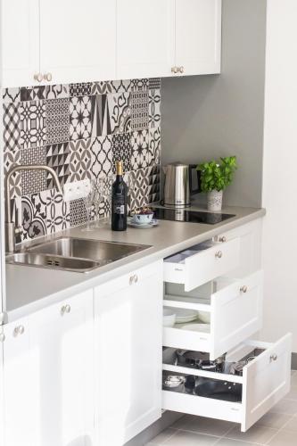 a kitchen with white cabinets and a sink at My Old Town Gdańsk - Apartamenty Długa 56 in Gdańsk