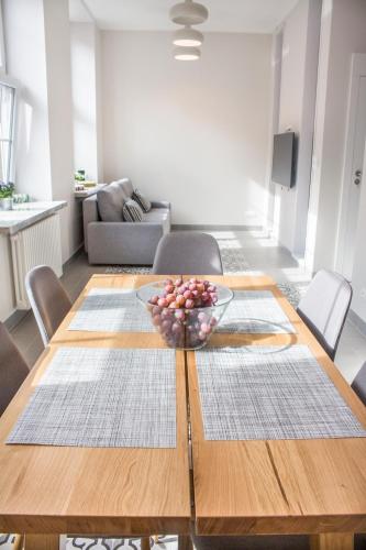a dining room table with a bowl of fruit on it at My Old Town Gdańsk - Apartamenty Długa 56 in Gdańsk
