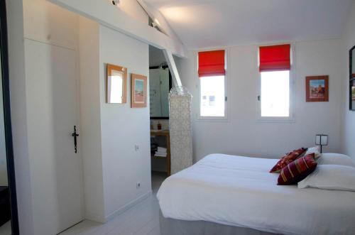 a bedroom with a white bed with red accents at La Ferrade Chambres d'Hôtes B&B in Bègles