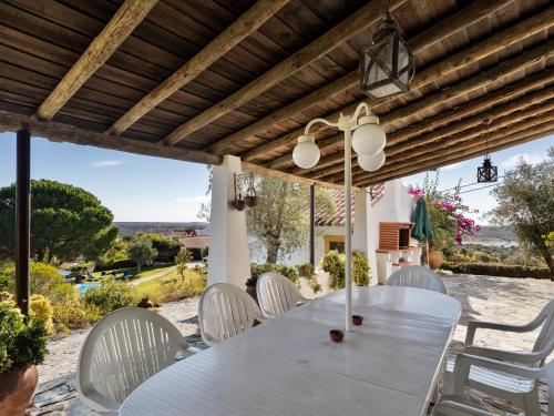 a white table and white chairs on a patio at Monte Velho Country House in Montargil