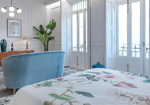 a bedroom with a bed and a blue chair at Casa Timoteo Apartamentos Boutique Adults Only in Alcoy