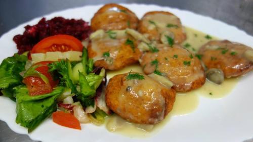 a plate of food with meat and vegetables on it at Willa Kapitańska i Willa Marynarska in Łeba