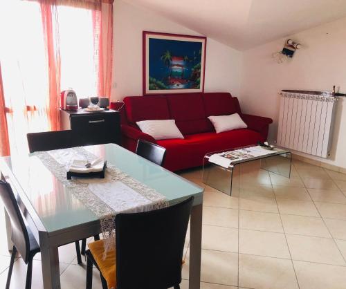 a living room with a red couch and a table at Appartamento Sofia in Montesilvano