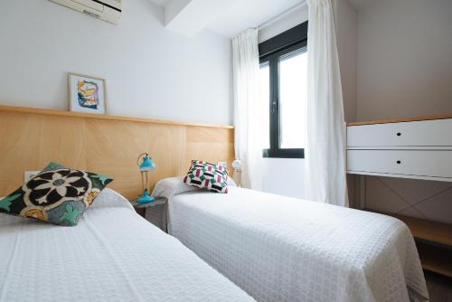 um quarto com 2 camas e uma janela em Apartamento Alameda em Sevilha