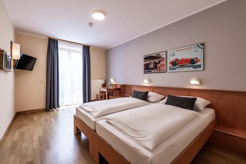 um quarto com uma cama grande e uma janela grande em JUFA Hotel Seckau em Seckau
