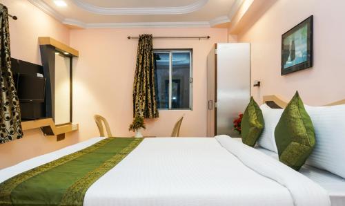 a bedroom with a large bed and a window at Treebo Hillway Inn Main Market in Mahabaleshwar