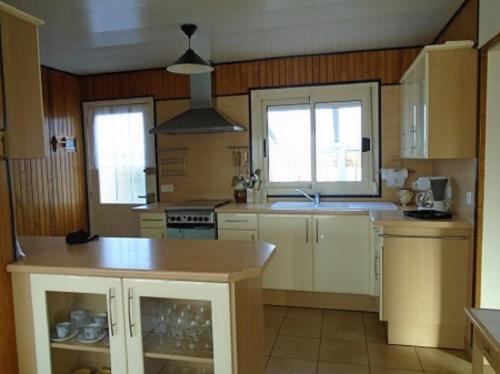 a kitchen with white cabinets and a island in it at ESCALE à FORT-BLOQUE 56 in Ploemeur