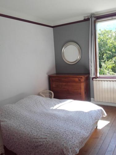Un dormitorio con una cama y un espejo y una ventana. en Barthoux, en Seythenex