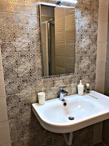 a white sink in a bathroom with a mirror at Napoli City Inn in Naples