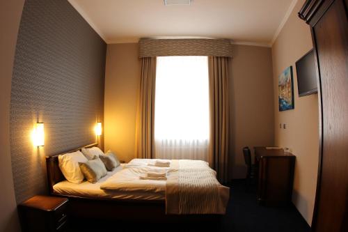a bedroom with a bed with a large window at Hotel Kamienica in Opole