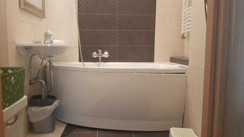 a bathroom with a bath tub and a sink at Sugár apartman in Debrecen