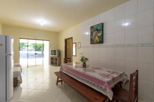 a living room with a table and a refrigerator at Pousada Dona Ema in Balneário Camboriú