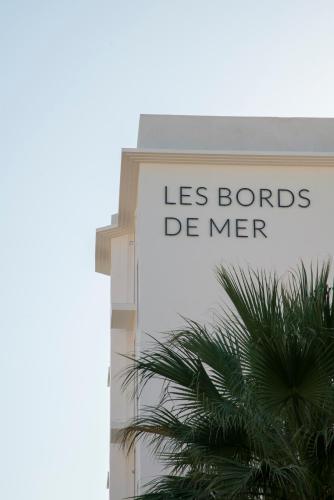 a sign on the side of a building with a palm tree at Les Bords De Mer in Marseille