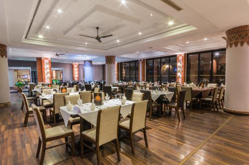 Zalagh Kasbah Hotel & Spa في مراكش: قاعة احتفالات مع طاولات وكراسي في غرفة