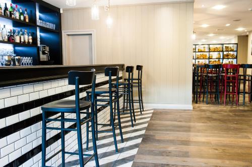 a row of stools at a bar in a restaurant at Macdonald Morlich Hotel at Macdonald Aviemore Resort in Aviemore