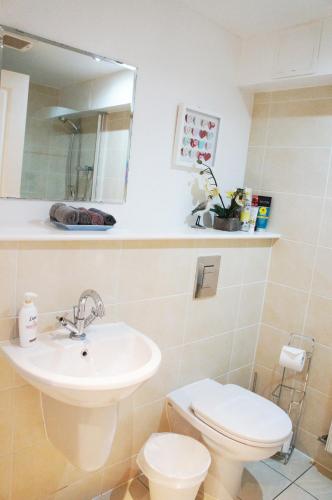 a bathroom with a sink and a toilet and a mirror at Cosy Apartment in Quiet City-Centre with Car Park in Glasgow