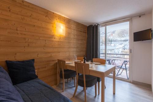 Cette chambre comprend une table, un lit et une fenêtre. dans l'établissement Relais de la Guisane, à Briançon