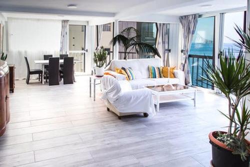 - un salon avec un canapé blanc et une table dans l'établissement Levante beach sea view, à Benidorm
