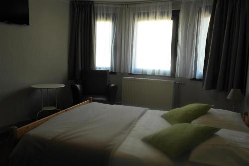 a bedroom with a large bed and a window at Zum Goldhahn in Amblève