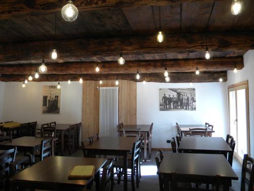 een eetkamer met tafels, stoelen en verlichting bij Cantina Alpina in Salabertano