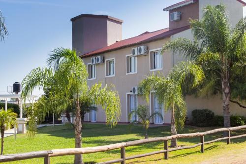 a house with palm trees in front of it at Club Valle Termal Resort in Federación