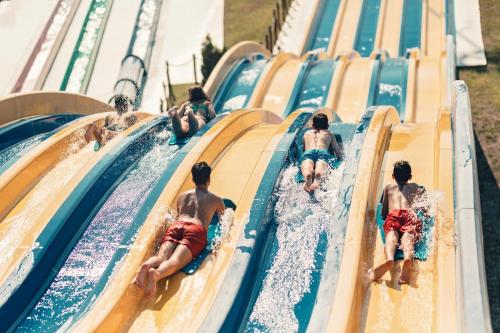 a group of children on a water slide at a water park at Appartement El Bahia Saidia destiné uniquement aux couple mariés, célibataires s'abstenir in Saidia 