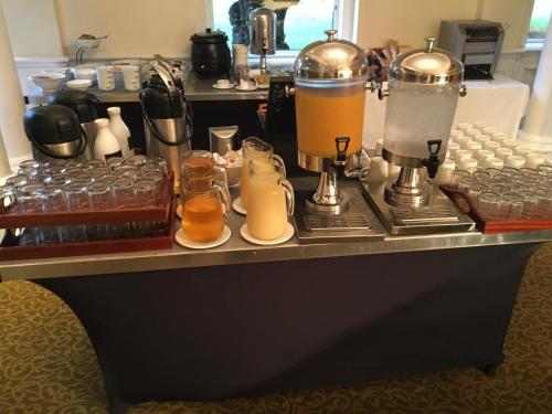 a counter with two coffee makers and some drinks at Winchester Wessex Hotel by Sunday in Winchester