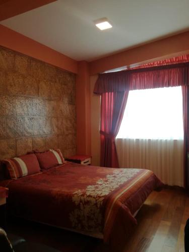 a bedroom with a large bed and a window at The Oruro Inn in Oruro