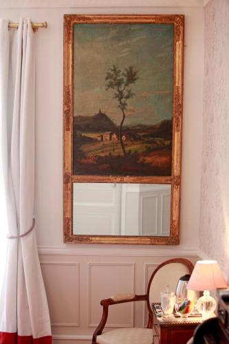 a painting hanging on a wall next to a window at Les Chambres de Mathilde in Angers