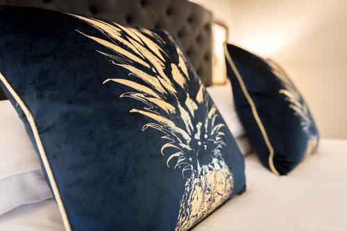two black and gold pillows on a bed at Cricket Field House in Salisbury