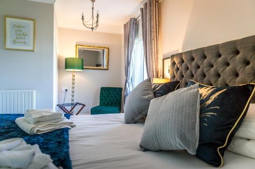 a bedroom with a large bed and a green chair at Cricket Field House in Salisbury