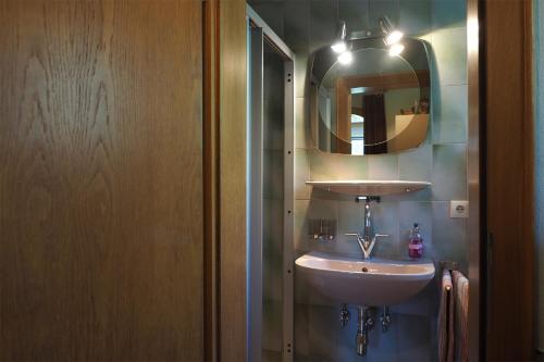 uma casa de banho com um lavatório e um espelho em Gästehaus Kratzer em Virgen