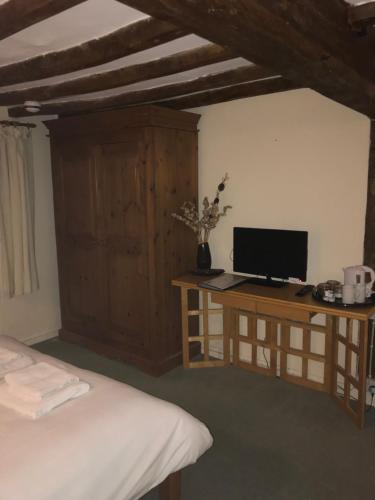 um quarto com uma cama e uma secretária com um computador em The Pear Tree em Hook Norton