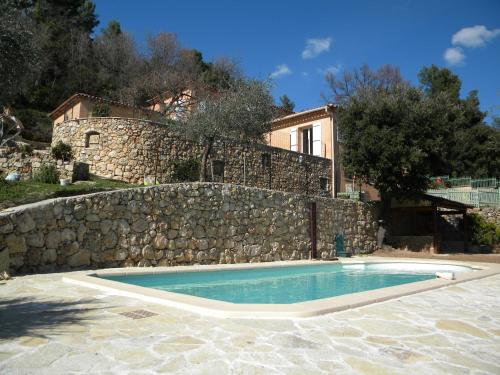 - une piscine en face d'un mur en pierre dans l'établissement Mas des Citronniers, à Le Tignet