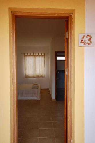 an open door to a bedroom with a bed in a room at Villa Maris Ecolodge in Morro