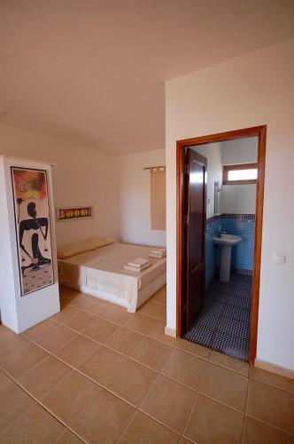 a room with a bed and a bathroom at Villa Maris Ecolodge in Morro