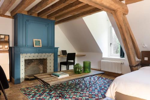 um quarto com uma lareira azul e uma cama em Le Manoir de la Plage / Adults Only em Honfleur
