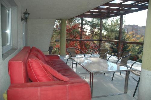 a red couch and a table on a balcony at Noclegi Jaworzno in Jaworzno