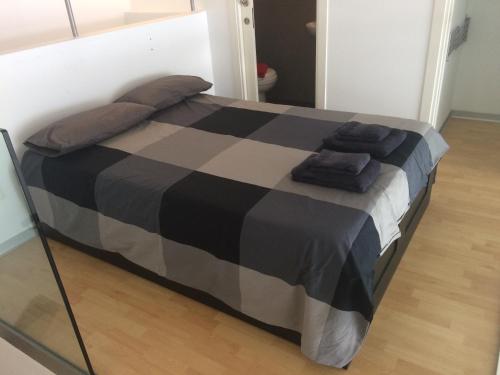 バレンシアにあるSUNNY DUPLEX LOFT WITH PUBLIC POOLのベッド1台(黒と灰色の毛布、枕付)