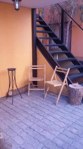 a staircase with two chairs and a table next to a building at Hotel Don Alfredo in Calama