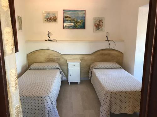 a bedroom with two beds and a night stand at Appartamenti Pagni in Casa Morcone