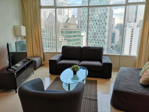 a living room with a couch and a table and a large window at VORTEX SUITES KLCC by PNUT With NETFLIX in Kuala Lumpur