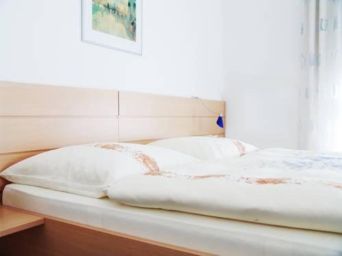 a bed with white sheets and pillows on it at Hotel Habana in Aalen