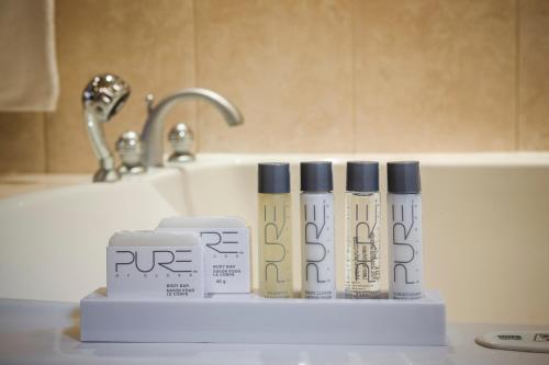 a bathroom counter with three products on a sink at Hotel Espresso Montreal Centre-Ville / Downtown in Montréal