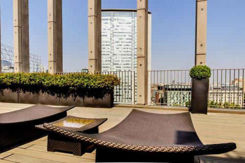 a balcony with two tables and a view of a building at Glam Milano in Milan