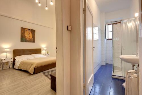 een slaapkamer met een bed en een badkamer met een wastafel bij Sleep Tight Florence Apartment in Florence