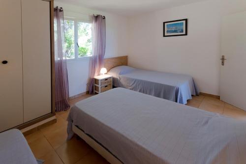 two beds in a room with a window at Domaine de Pianiccia in Sari Solenzara