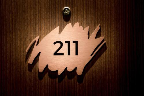 a clock with the number on a wooden wall at KOPSTER Hotel Lyon Groupama Stadium in Décines-Charpieu