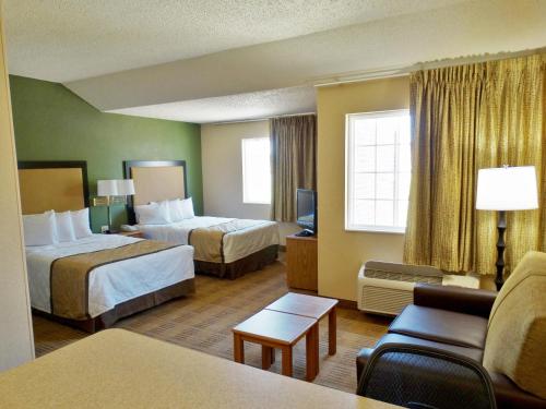 ルイスビルにあるExtended Stay America Suites - Louisville - Alliant Avenueのベッド2台とソファが備わるホテルルームです。
